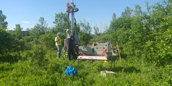 technicians working to take a soil sample.